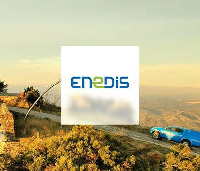 Logo Enedis avec en fond une route en terre et une voiture