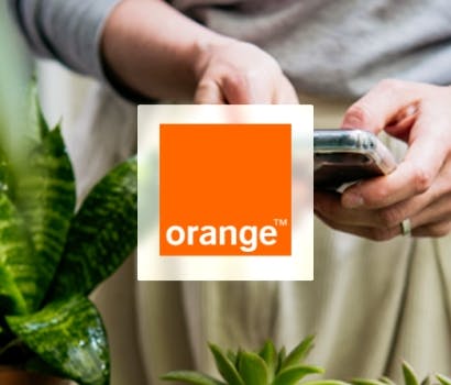 Logo Orange devant un utilisateur de Smartphone